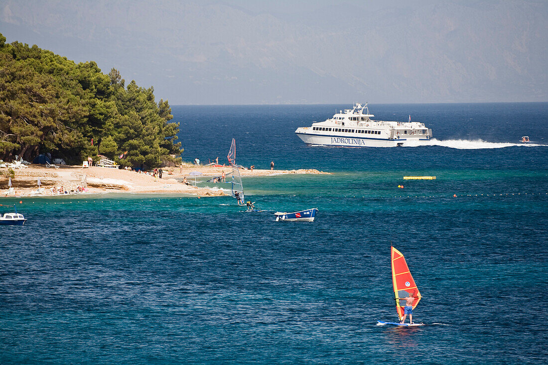 Ein Schiff und Surfer vor dem Strand am Goldenen Horn, Bol, Insel Brac, Dalmatien, Kroatien, Europa