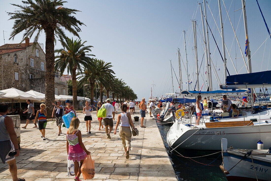 Menschen bummeln auf der Promenade im Jachthafen von Hvar, Insel Hvar, Dalmatien, Kroatien, Europa