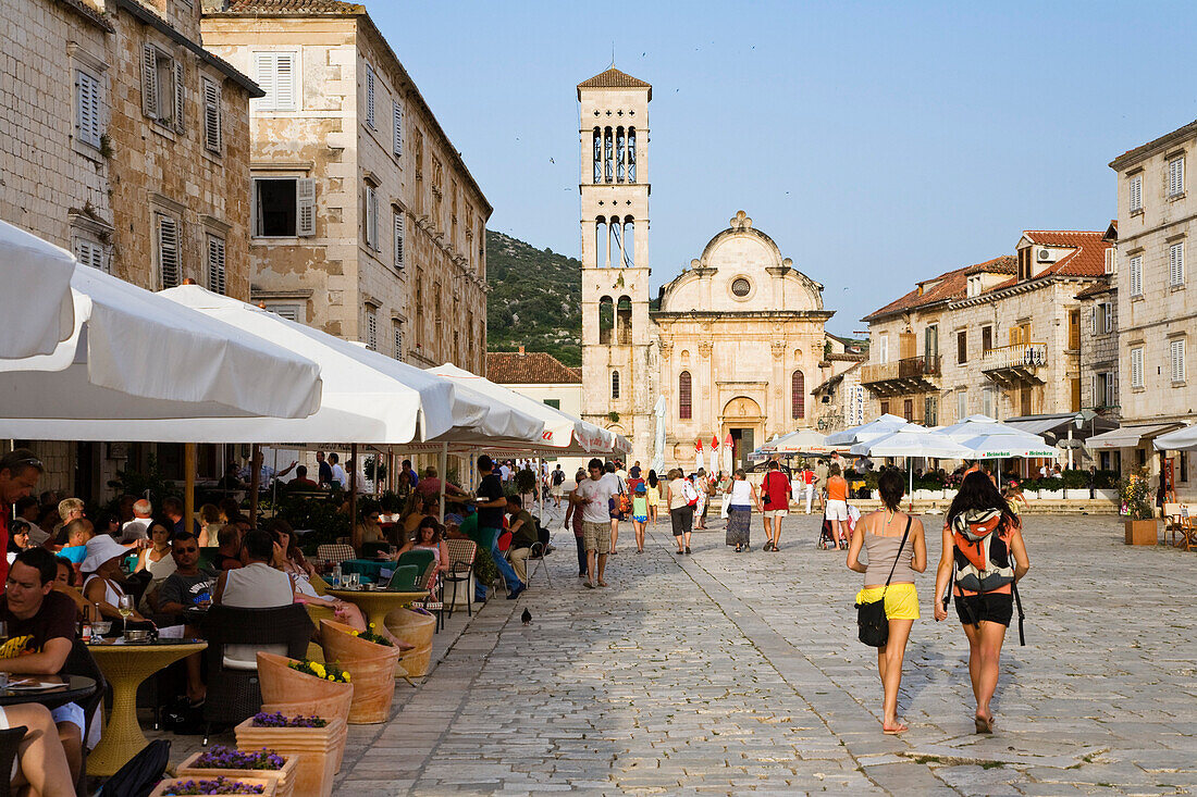 Menschen sitzen in Strassencafes in der Altstadt von Hvar, Insel Hvar, Dalmatien, Kroatien, Europa