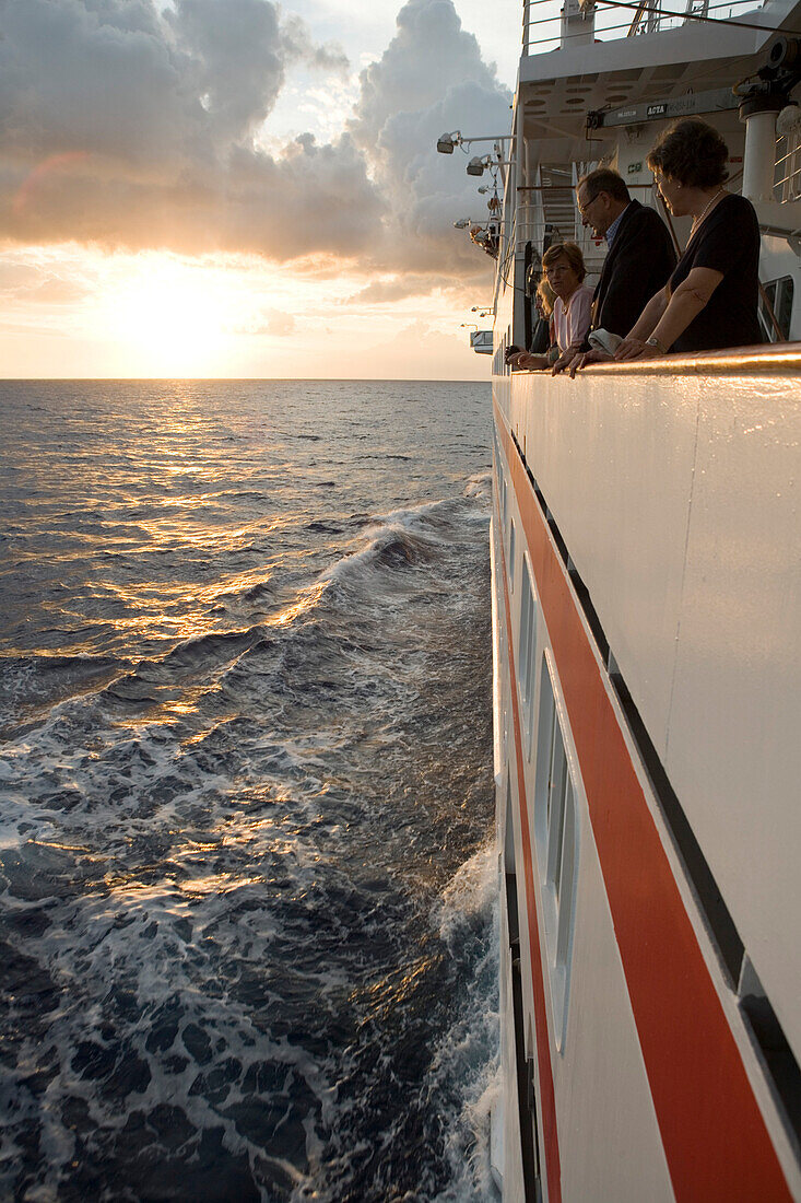 Passagiere blicken vom Kreuzfahrtschiff MS Hanseatic in den Sonnenuntergang, nahe Port Louis, Mauritius, Indischer Ozean