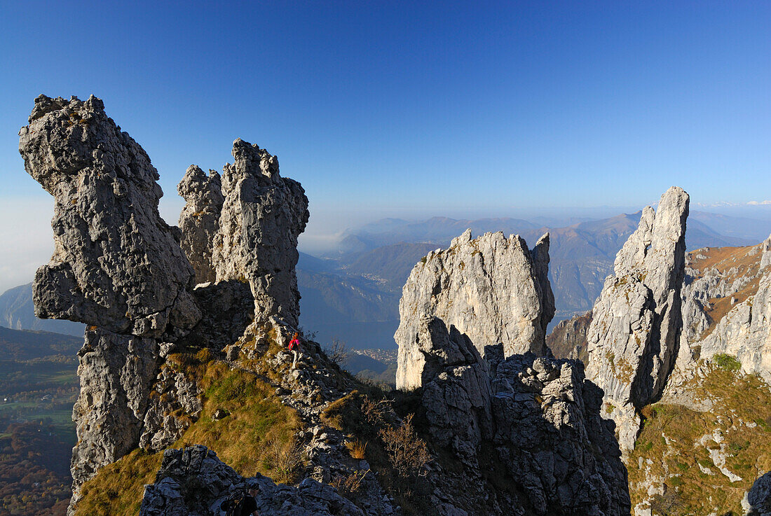 Woman hiking between pinnacles of Grigne, Bergamo Alps, Como, Lombardy, Italy