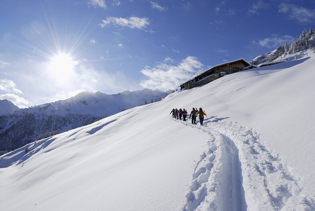 Skitourengeher beim Aufstieg zu einer Almhütte, Wiedersberger Horn, Kitzbüheler Alpen, Tirol, Österreich