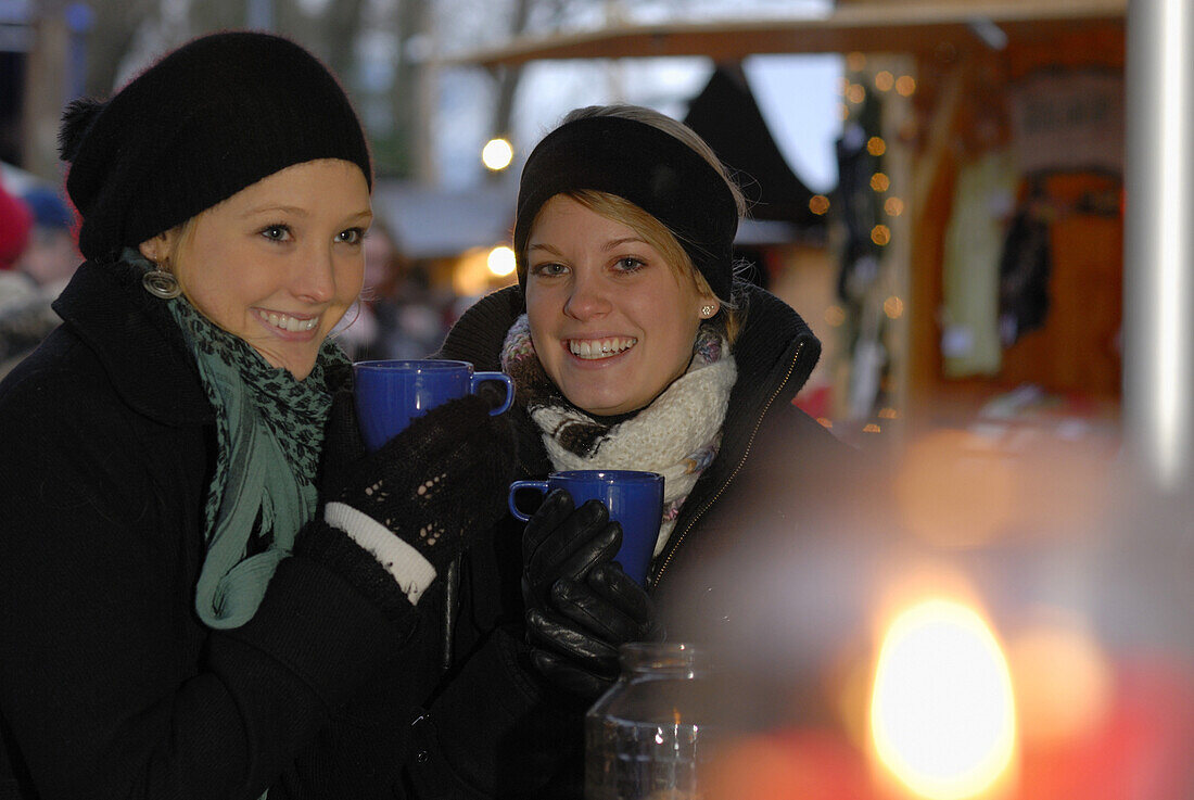 Zwei junge Frauen auf einem Weihnachtsmarkt, Frauenchiemsee, Chiemgau, Bayern, Deutschland