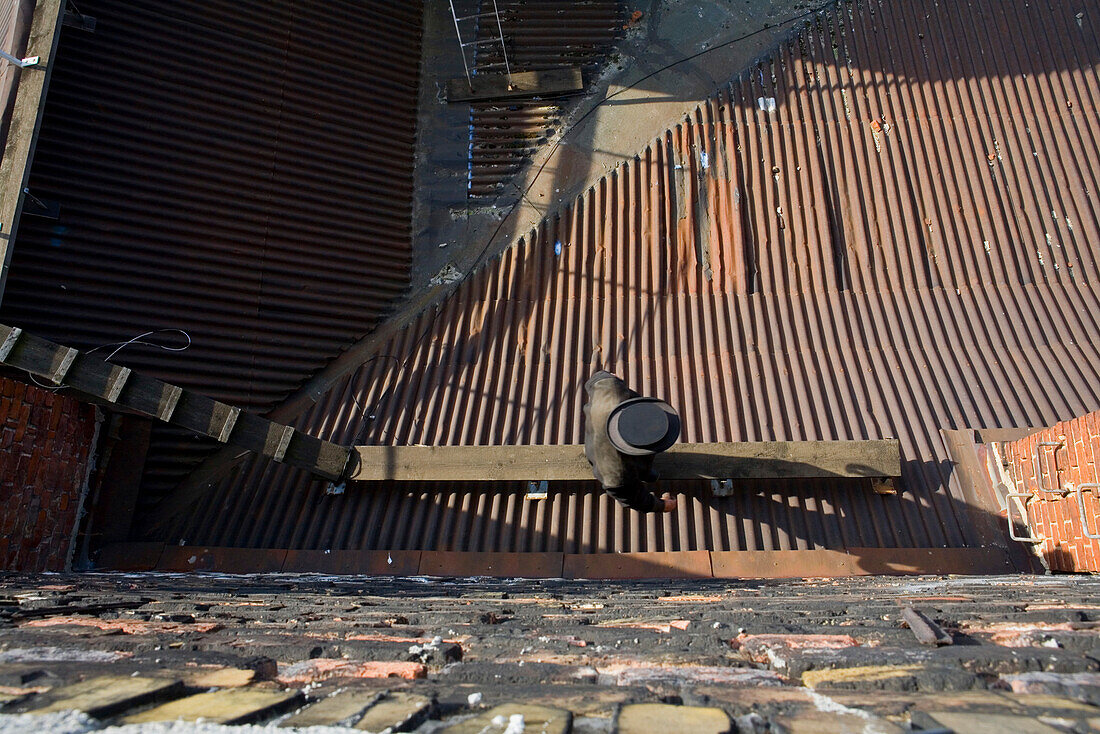 Chimney sweep on corrugated iron roof, Berlin, Germany