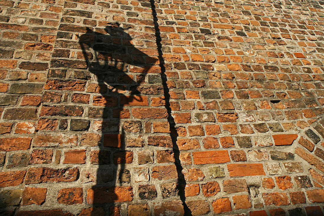 Schatten einer Gaslaterne auf Ziegelwand