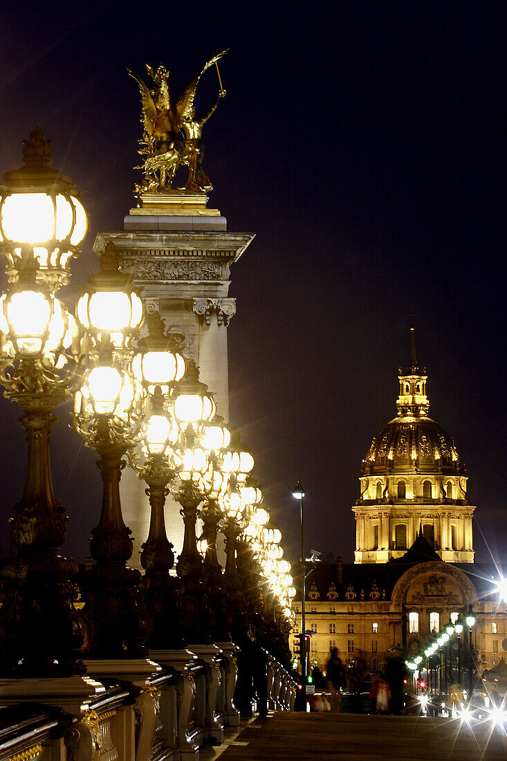 The night view of Pont Alexandre III with the Dome Church of Hotel Invalides in  the background. Paris. France