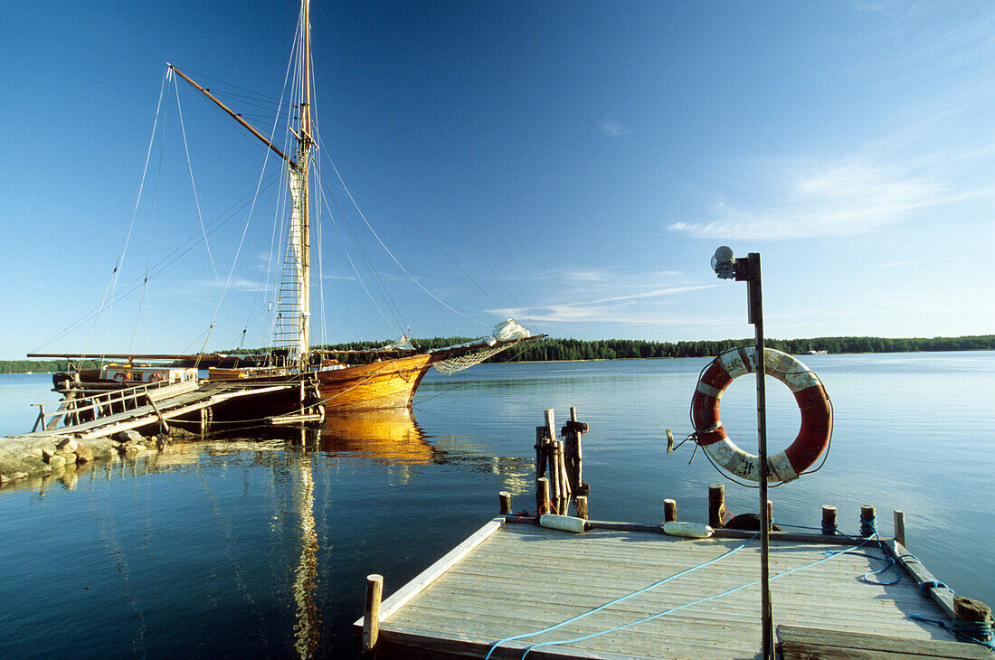 Blick auf ein Boot an einem Steg in den Schären, Finnland, Europa