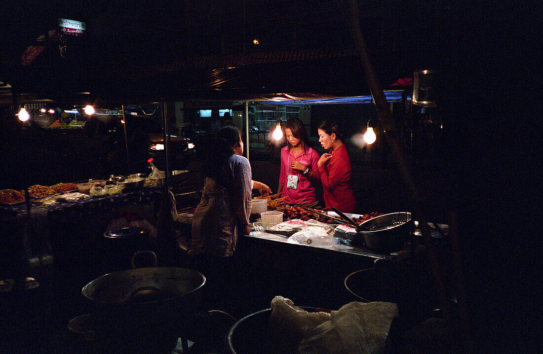 Frauen an einem Imbiss bei Nacht, Bangkok, Thailand