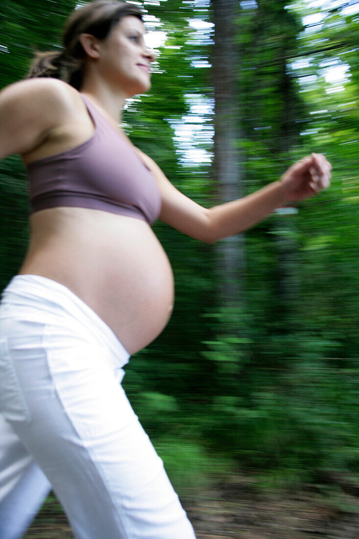 Pregnant woman walking in forest