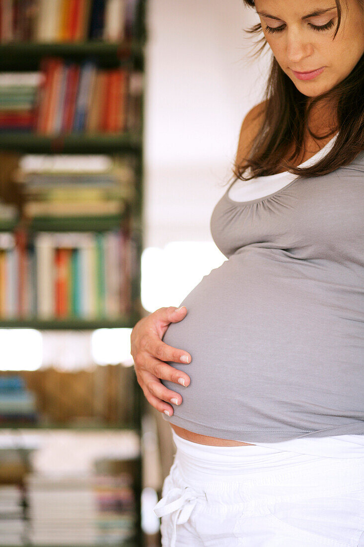 Schwangere Frau berührt ihren Bauch