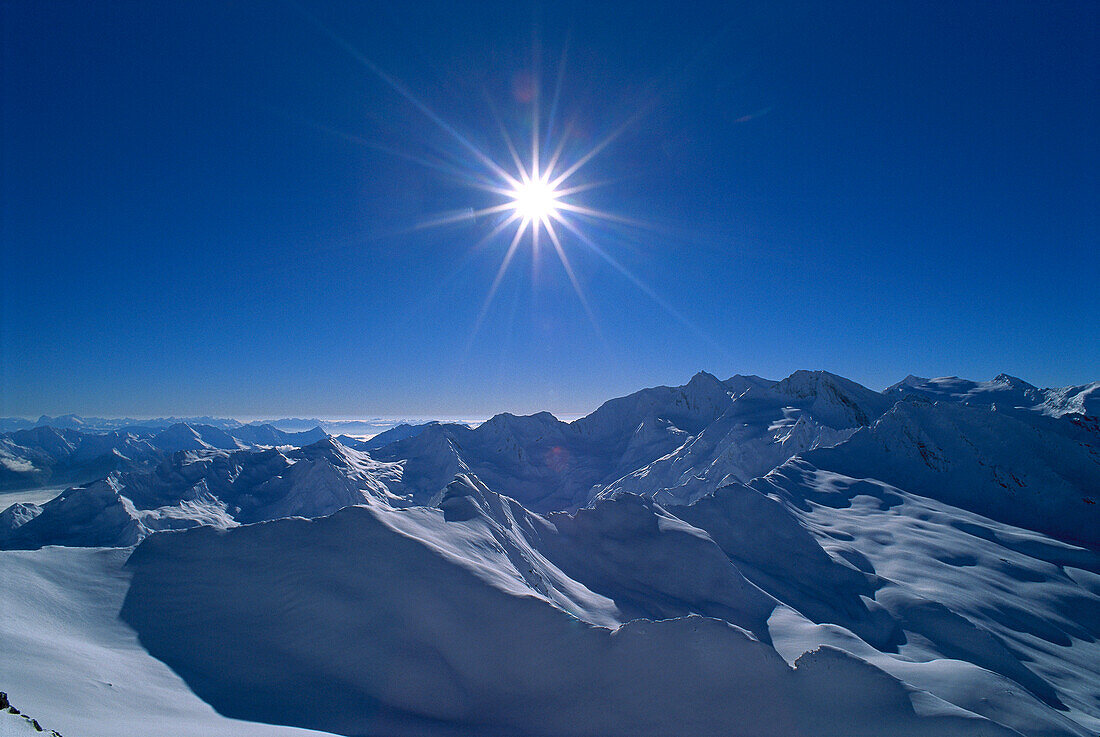 Blick über schneebedeckte Bergkette unter blauem Himmel, Alpen, Südtirol, Italien, Europa