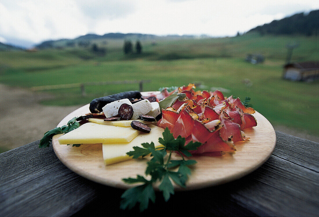 Ein Brett mit Schinken und Käse, Aussicht auf eine Alm, Südtirol, Italien, Europa