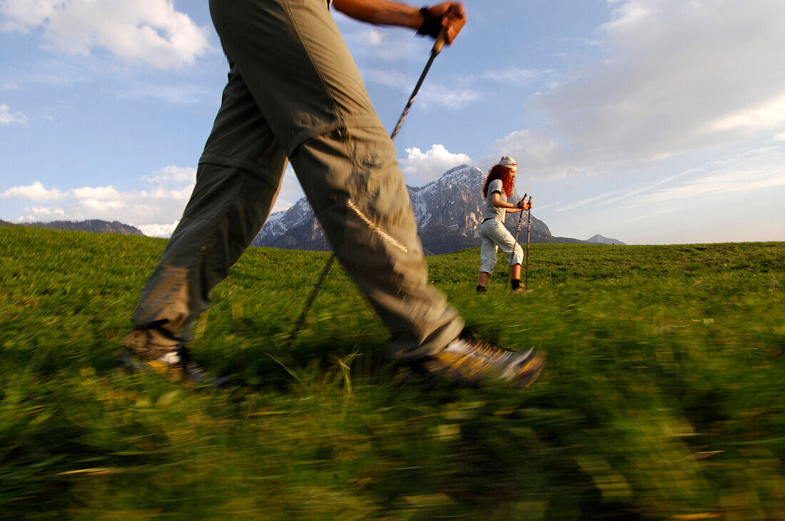 Eine Frau und ein Mann beim Nordic Walking in einer Berglandschaft, Schlern, Südtirol, Italien, Europa