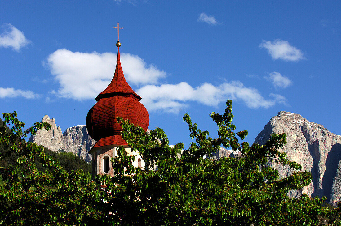 Der Kirchturm der St. Oswald Kirche hinter grünen Zweigen, Kastelruth, Südtirol, Italien, Europa