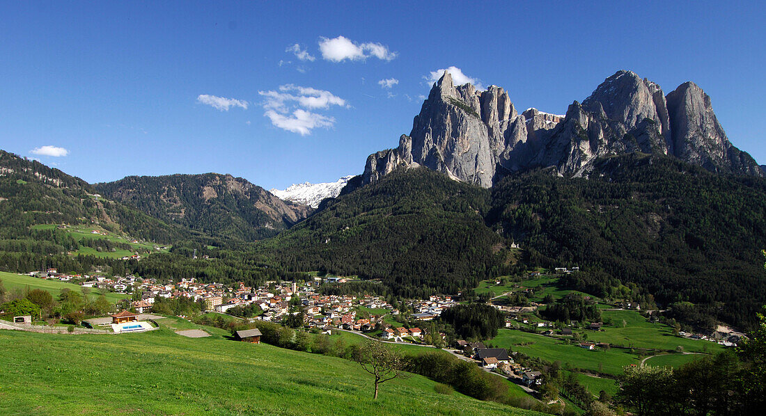 Blick auf ein Dorf in einem Tal unter blauem Himmel, Seis am Schlern, Südtirol, Italien, Europa