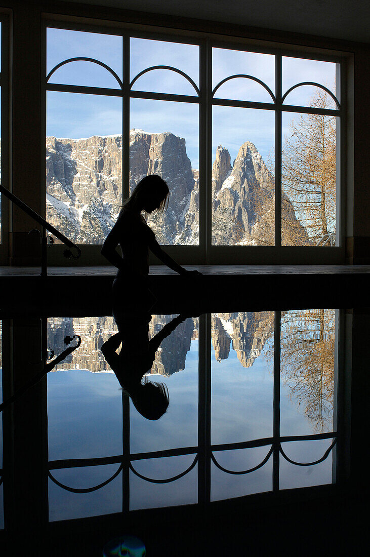 Frau in einem Schwimmbad im Gegenlicht, Aussicht auf Berglandschaft, Schlern, Südtirol, Italien, Europa