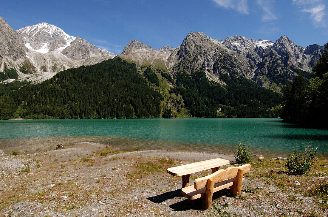 Bench and table at the bank of Antholzer lake in the sunlight, Val Pusteria, South Tyrol, Italy, Europe
