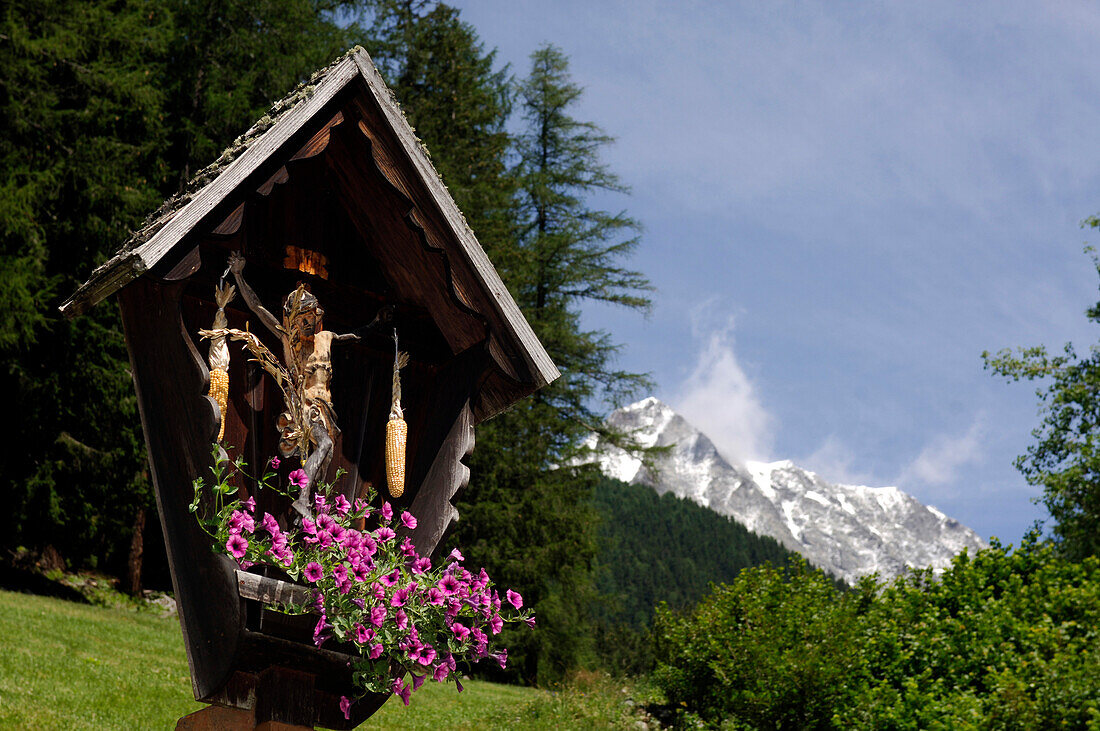 Wegkreuz mit Blumen vor idyllischer Berglandschaft, Pustertal, Südtirol, Italien, Europa