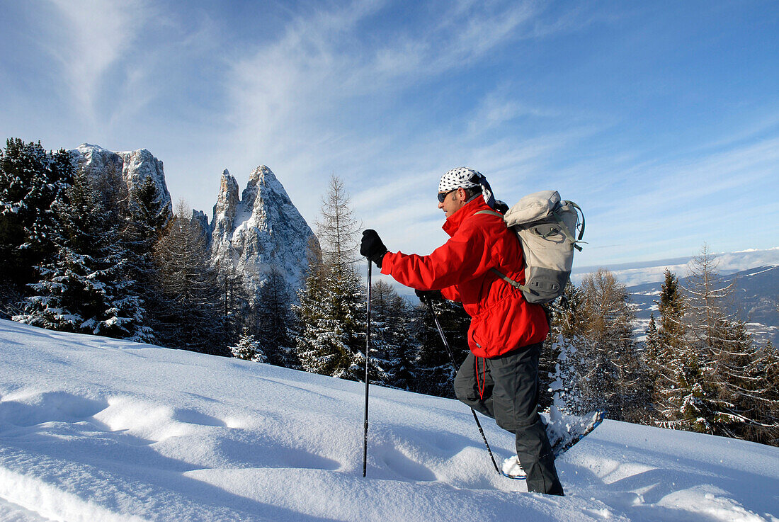 Ein Mann mit Rucksack beim Schneeschuhwandern, Seiser Alm, Südtirol, Italien, Europa