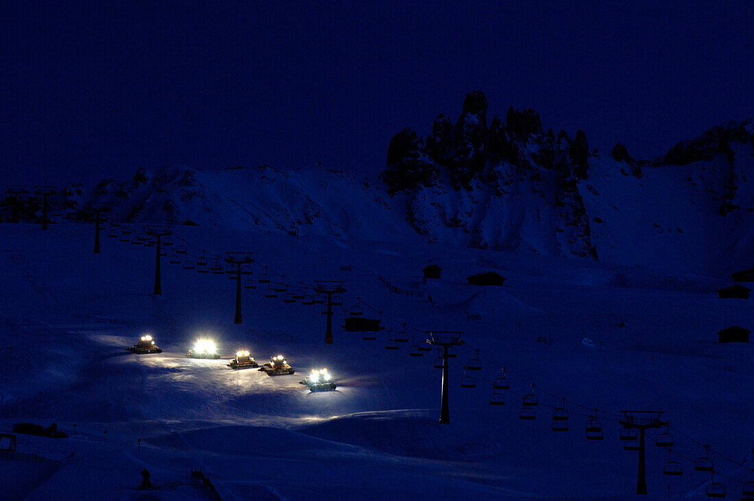 Raupenfahrzeuge bearbeiten bei Nacht die Skipiste, Südtirol, Italien, Europa