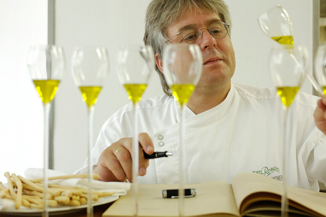 Ein Koch kostet Olivenöl, Restaurant zur Rose, Südtirol, Italien, Europa