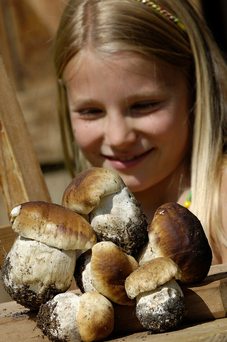 Close up of wild mushrooms, girl in the background. South Tyrolean speciality, Gastronomy, South Tyrol, Italy