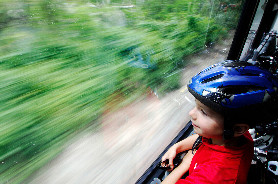 Kind schaut durch den Fenster, Fahrradtour durch den Vinschgau mit der Vinschger Bahn, Bahn und Bike, Vinschgau, Südtirol, Italien