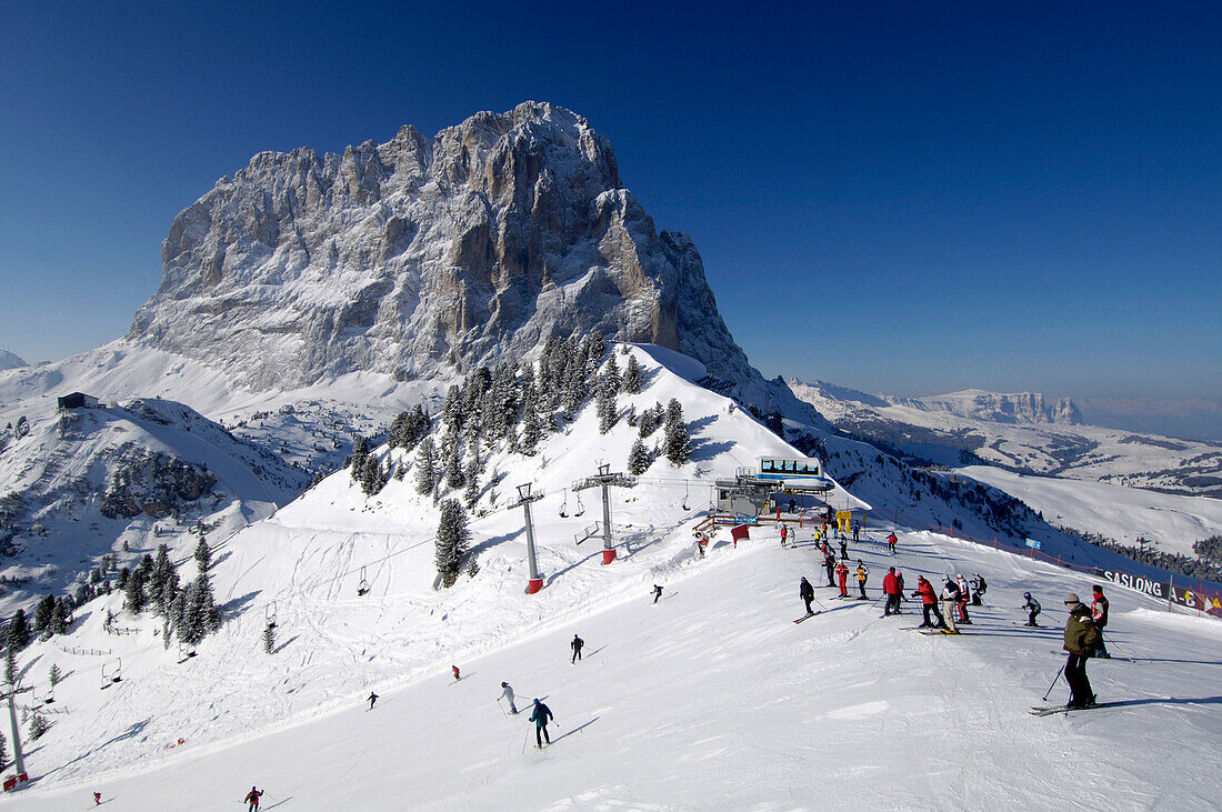 Skiers on a ski slope near the summit station, Mountain landscape in Winter, Sella Ronda, Gherdeina, Val Gardena, South Tyrol, Italy