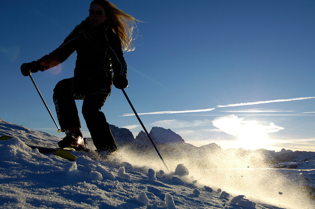 Female skier skiing down a slope, Seiser Alm, Langkofel mountain range, South Tyrol, Italy