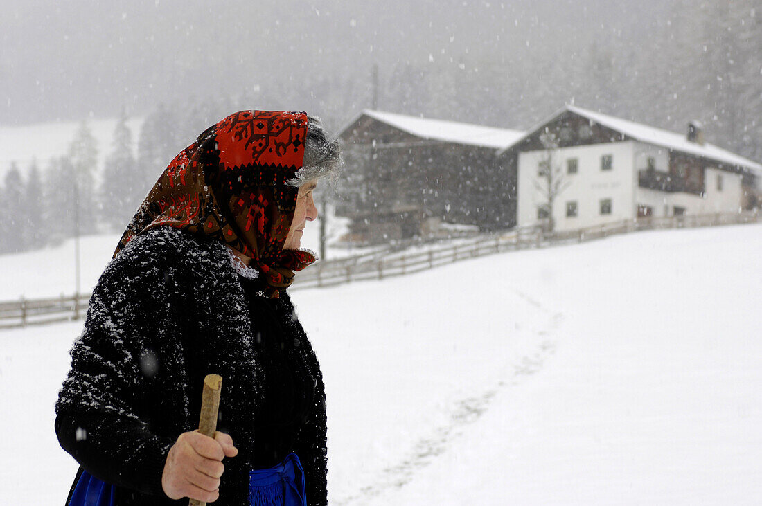 Bäuerin geht durch den Schnee, Bauernhof, Landwirtschaft, Südtirol, Italien