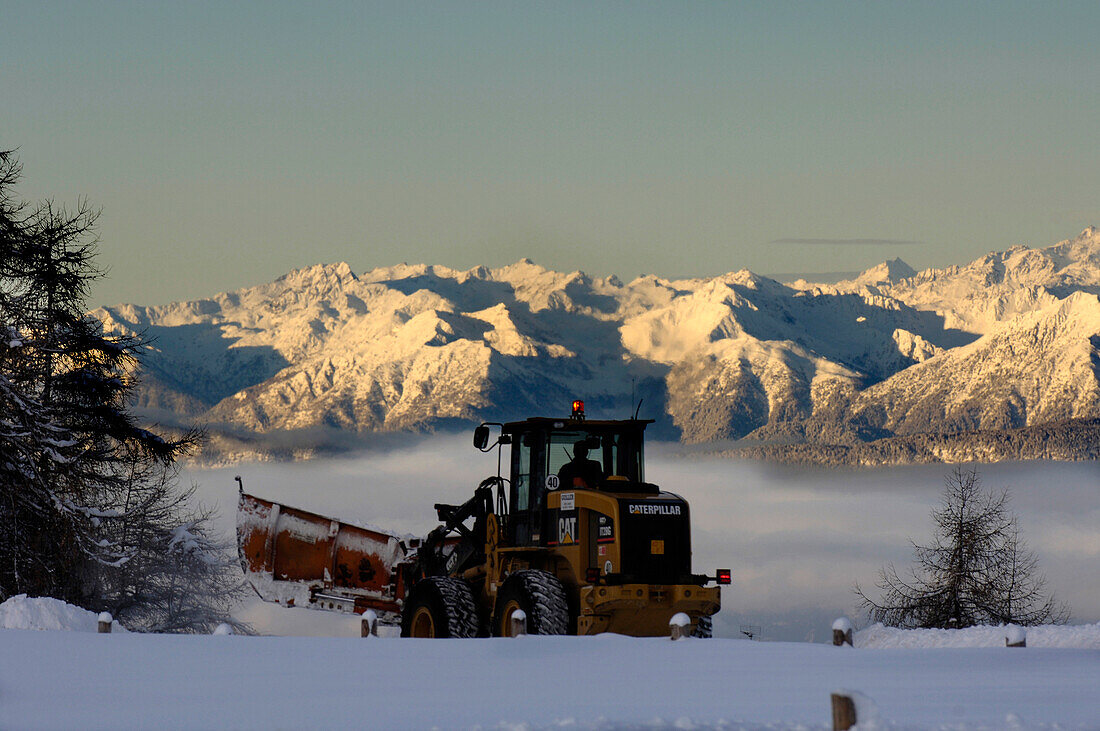 Snow plough clearing snow in the morning light, Seiser Alm, South Tyrol, Italy