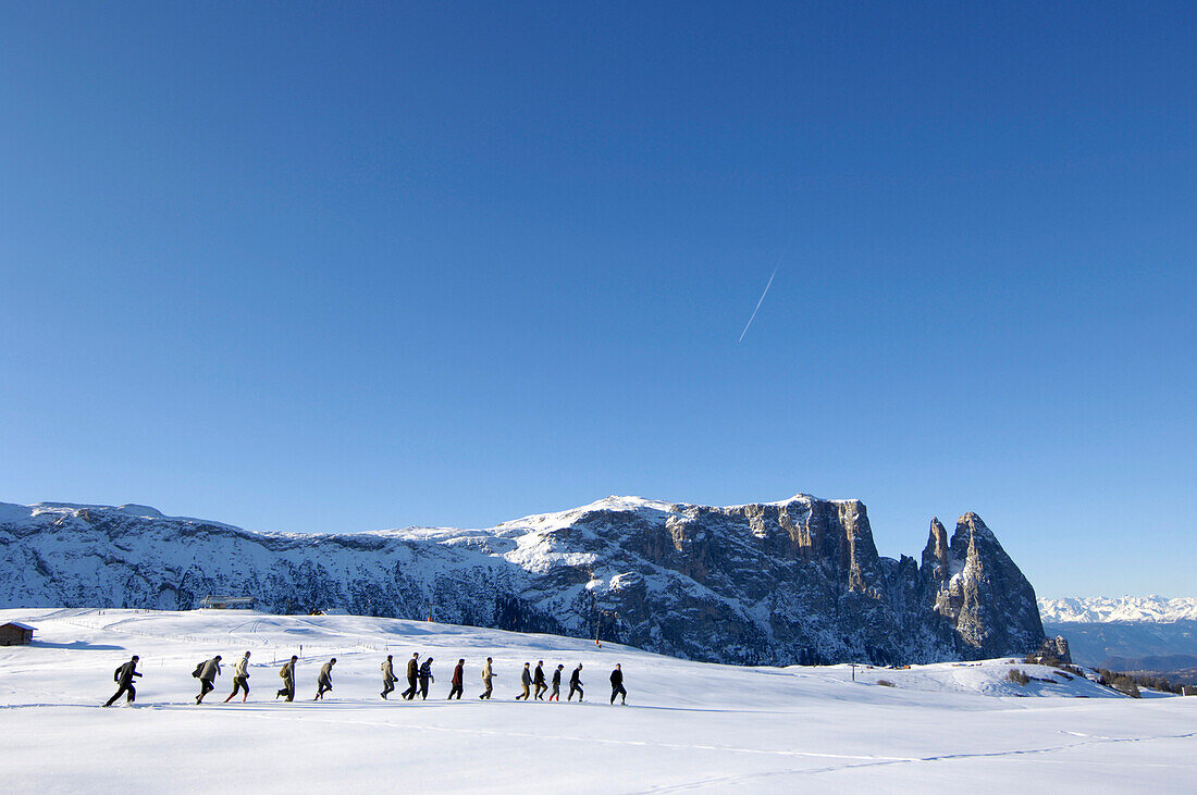 A group of men running through the snow, Seiser Alm, South Tyrol, Italy