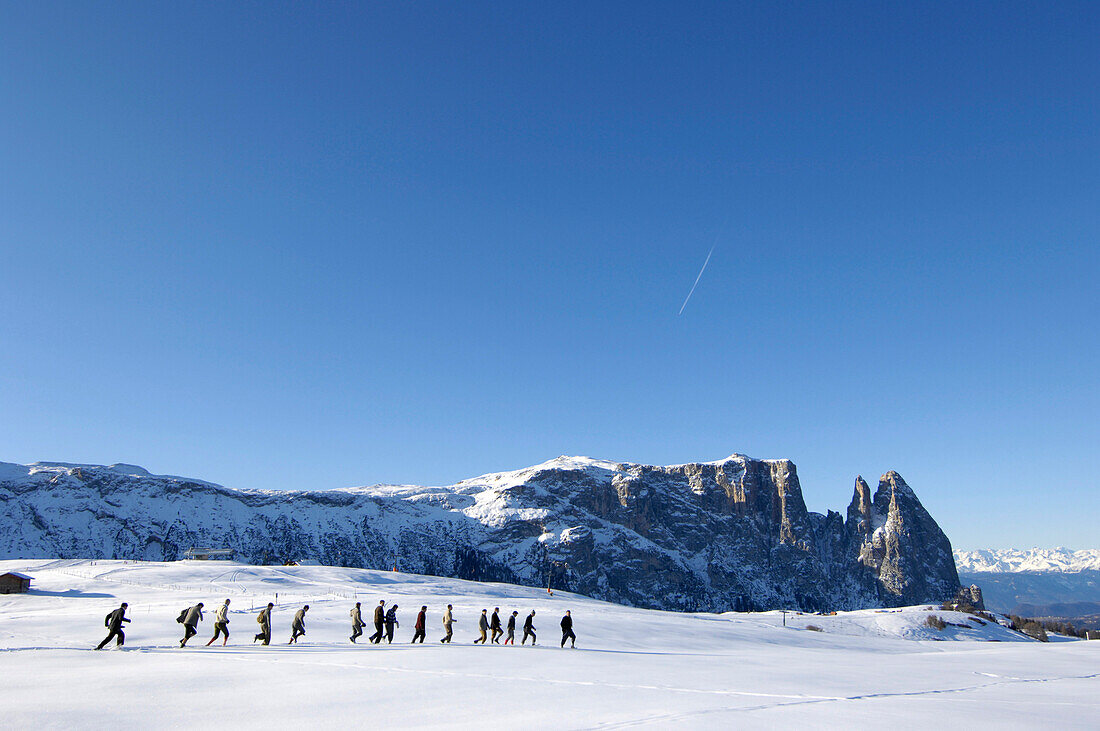 Eine Gruppe Männer laufen durch den Schnee, Seiser Alm, Südtirol, Italien