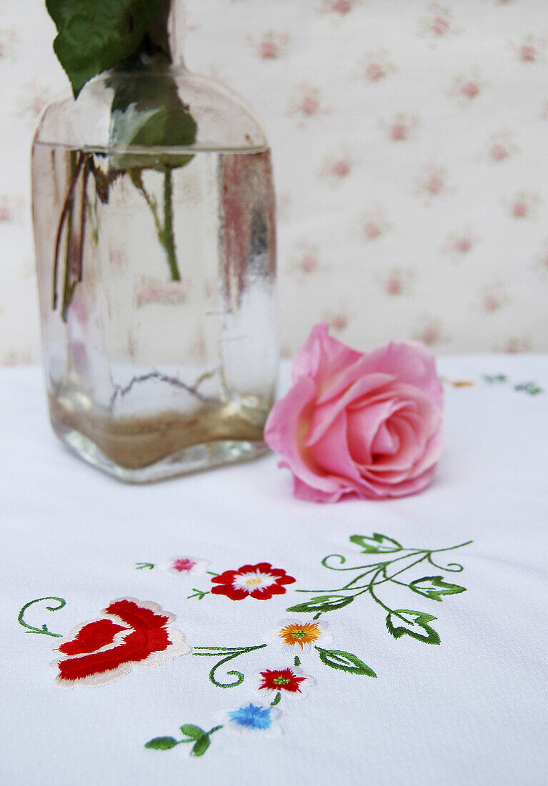 Rose on embroidered tablecloth