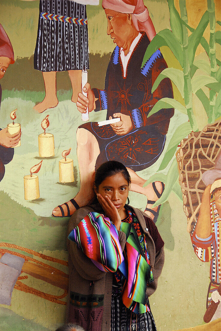 Woman in front of mural painting, Chichicastenango. Guatemala