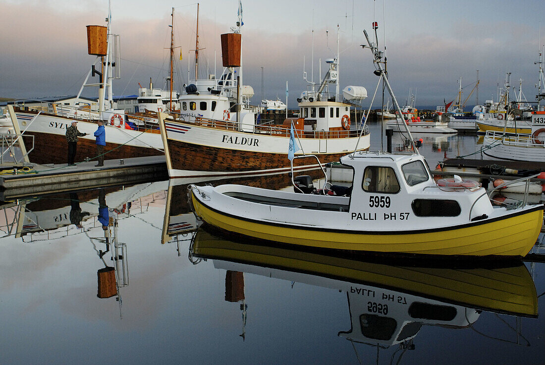 Fishing boats at port under the midnight sun, Husavik. Iceland