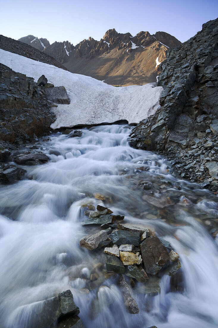 Water rushes from below a melting snow bridge at the outlet to Wrights Lake below Mt  Sneffels, San Juan Mountains, Colorado, USA