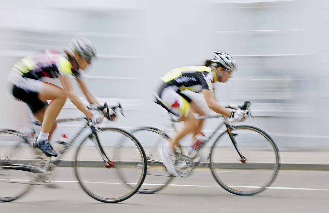 Cyclists compete in a road race in Warwick, England, UK