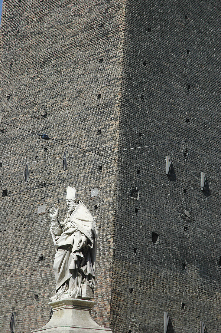 Bologna (Italy), San Petronio's statue, in front of Garisenda Tower