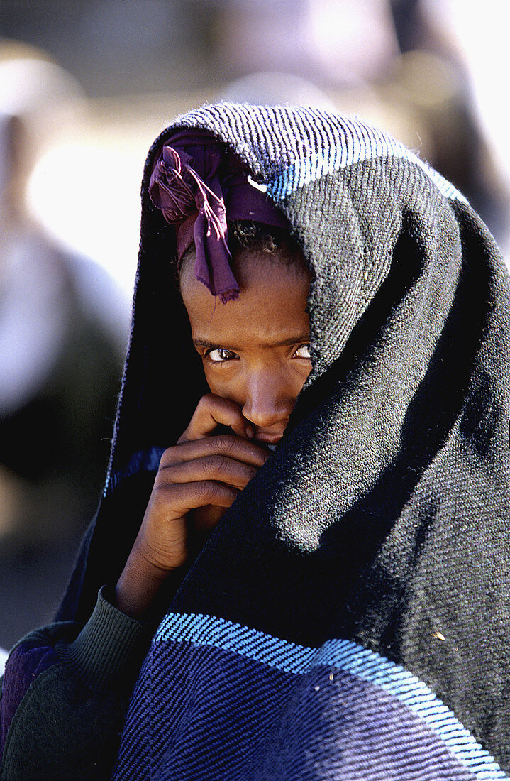 Beautiful Ethiopian girl covered by her quilt. Photo taken during the big sunday market of Debre Birhan.