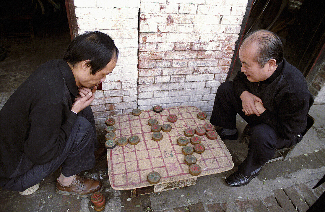 Men play Xiangqi (Chinese Chess). Street scene in Shanxi province, China