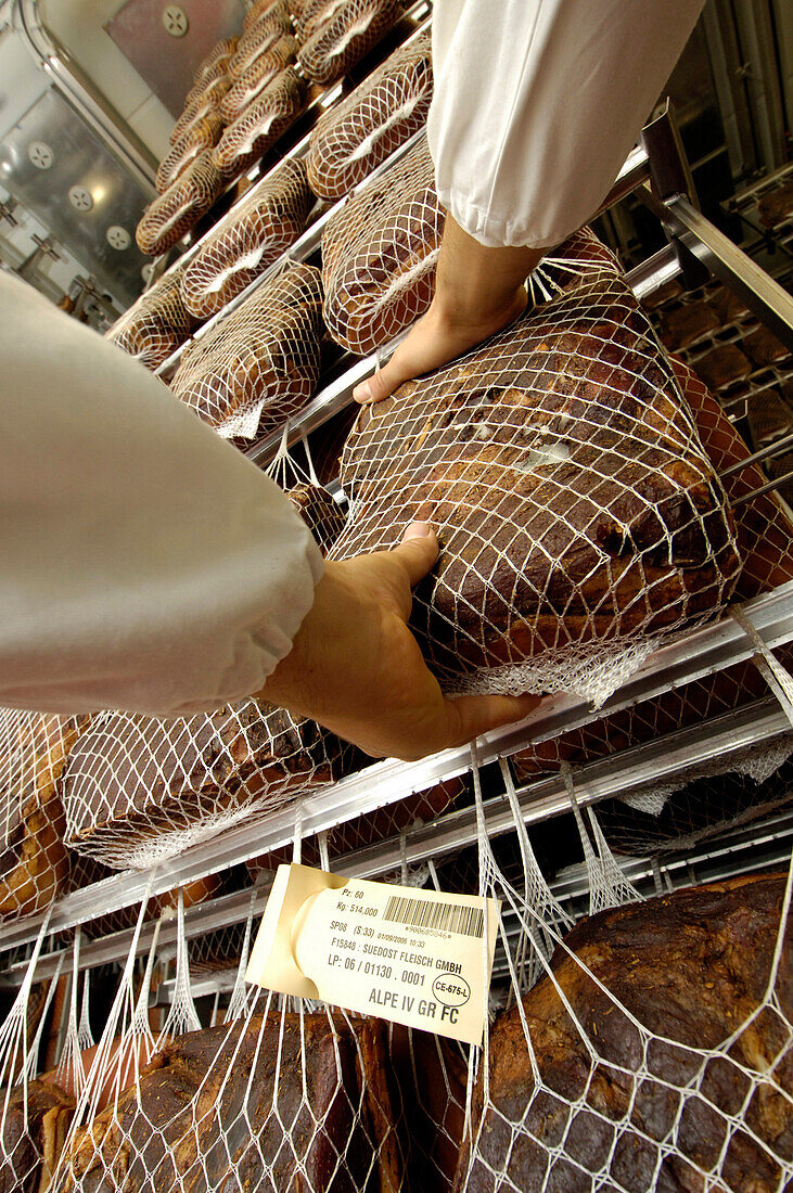 Two hands on a piece of speck at a storage, South Tyrol, Italy, Europe