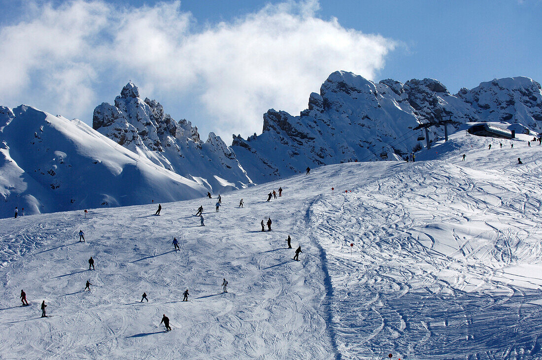 Blick auf Skifahrer auf einer Skipiste unter Wolkenhimmel, Seiser Alm, Dolomiten, Südtirol, Italien, Europa