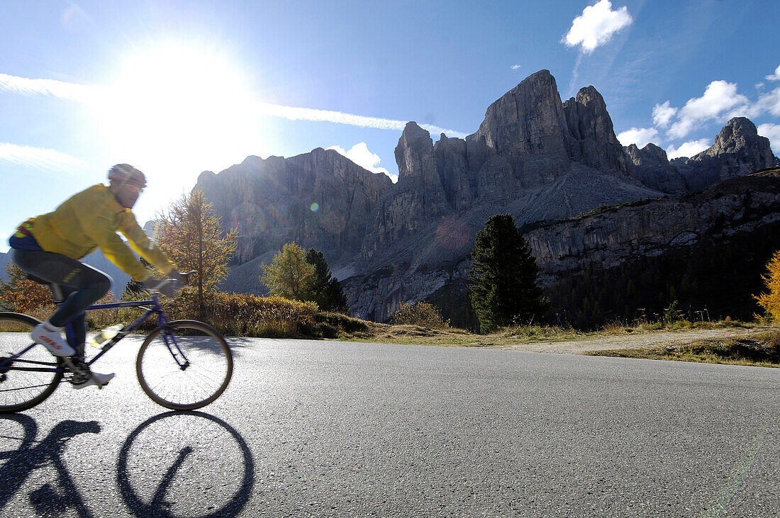 Cyclist on a mountain pass in the sunlight, Dolomites, South Tyrol, Italy, Europe