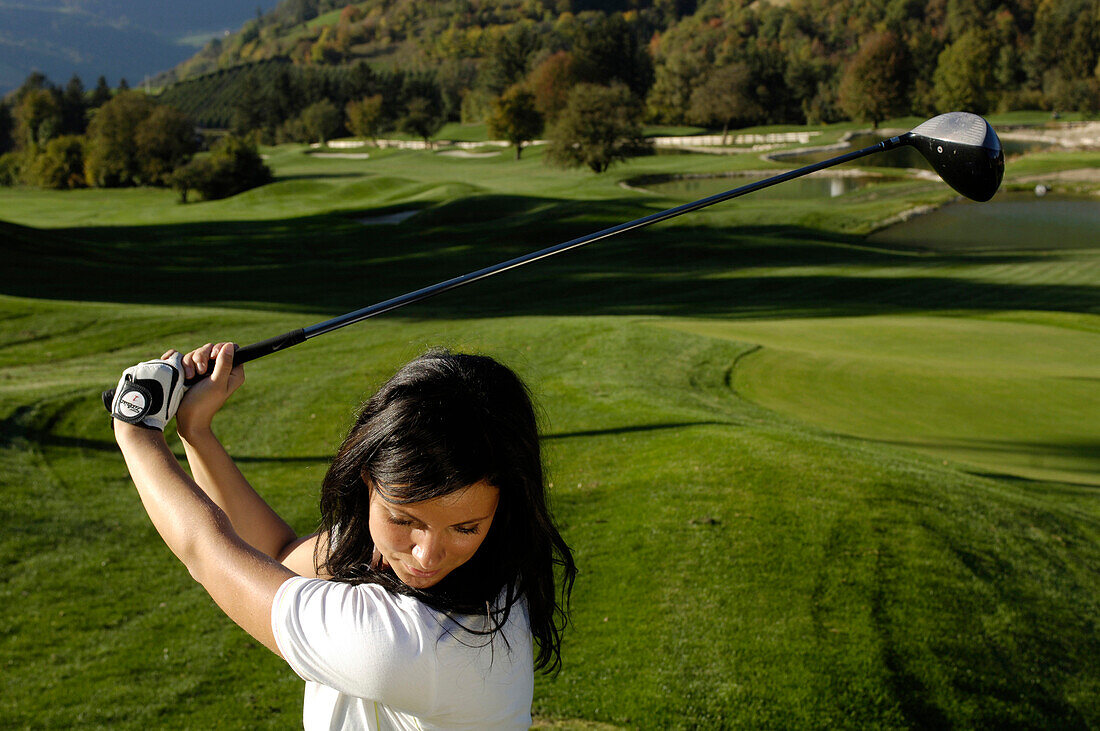 Eine Frau mit Golfschläger auf dem Rasen des Golfplatz Kastelruth Seiser Alm, Schlern, Südtirol, Italien, Europa
