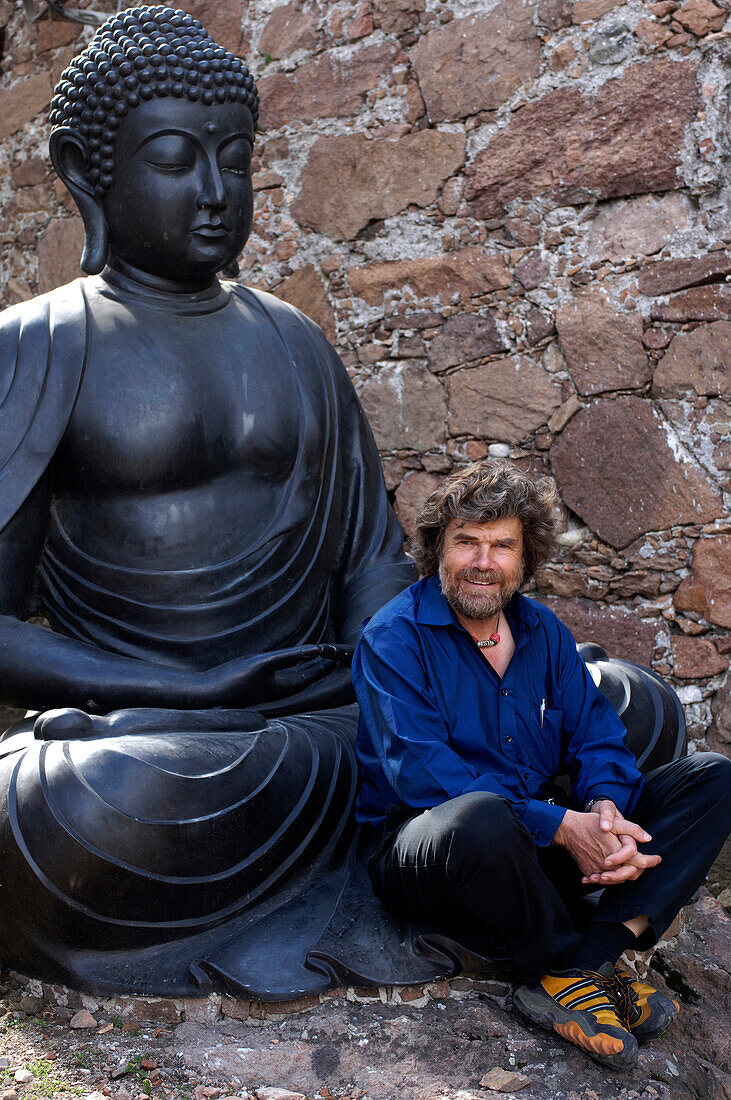 Reinhold Messner vor Buddha Statue, Extrembergsteiger und Buchautor, MMM, Messner Mountain Museum, Südtirol, Italien