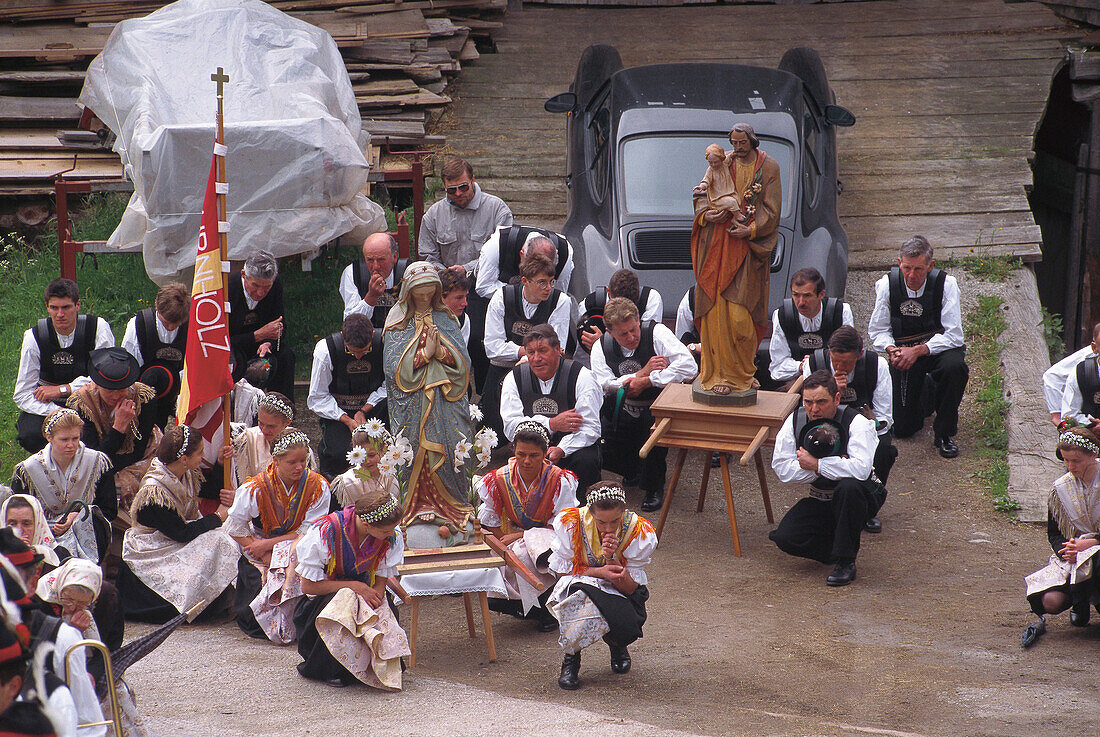 Fronleichnam Prozession durch Sarntal, Leute in Sarntaler Tracht Beten zum Heiliger Joseph und Maria, Südtirol, Italien