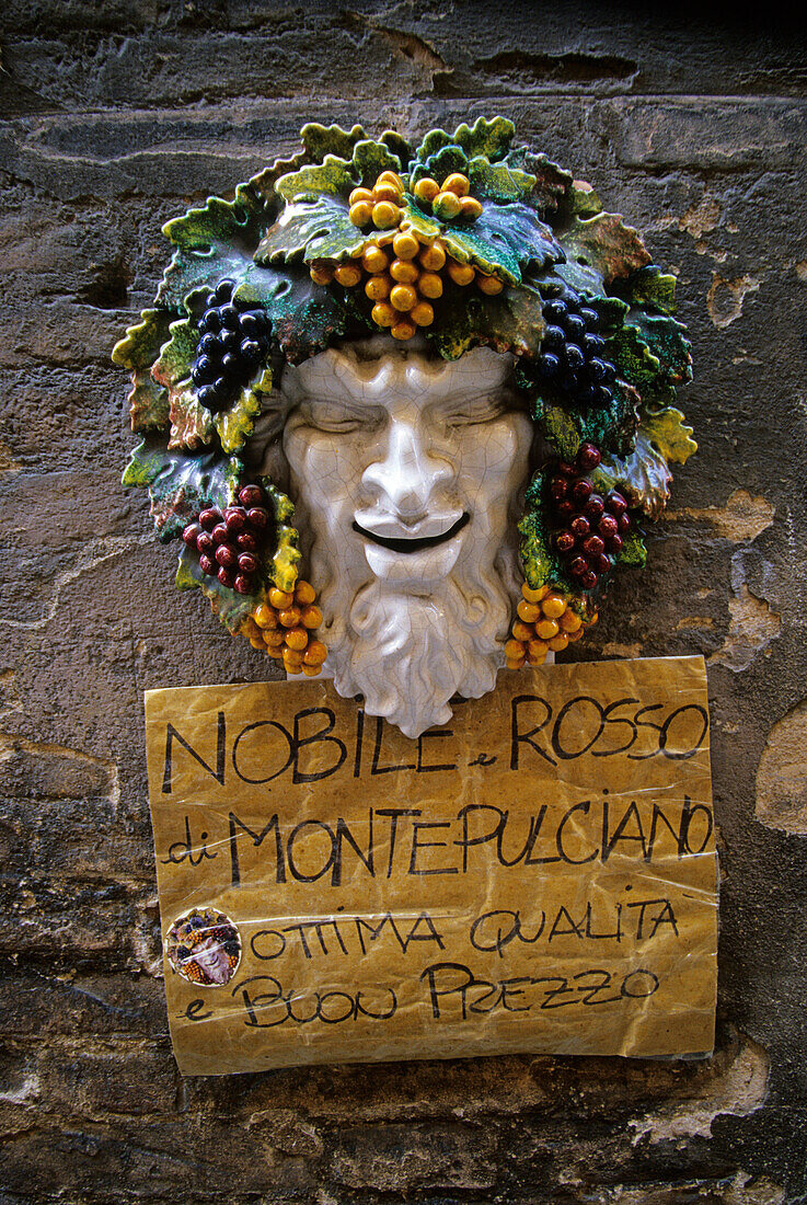 Advertising for wine, ceramic figure and a sign on a wall, Siena, Tuscany, Italy, Europe