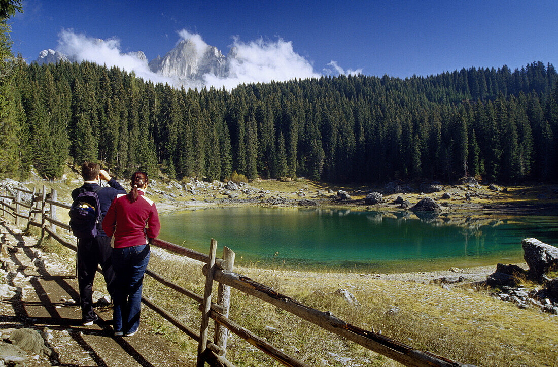 Zwei Wanderer betrachten den Aussicht, Karer See, Blick zum Rosengarten, Dolomiten, Südtirol, Italien