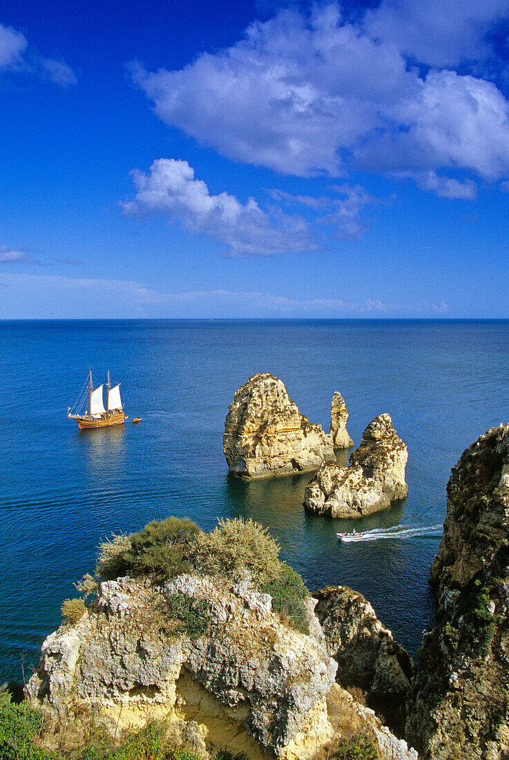 A sailing ship off a rocky coast in the sunlight, Ponta da Piedade, Algarve, Portugal, Europe